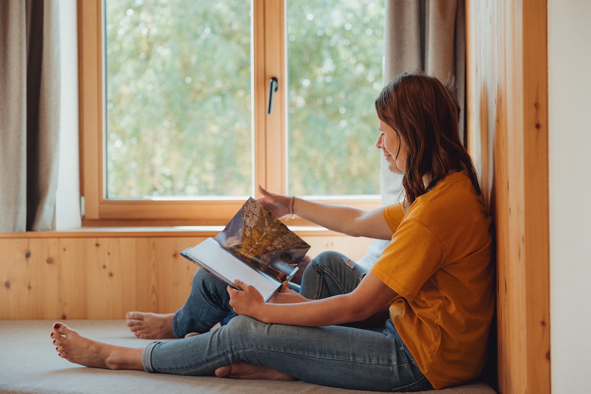Frau liest am Fensterbett