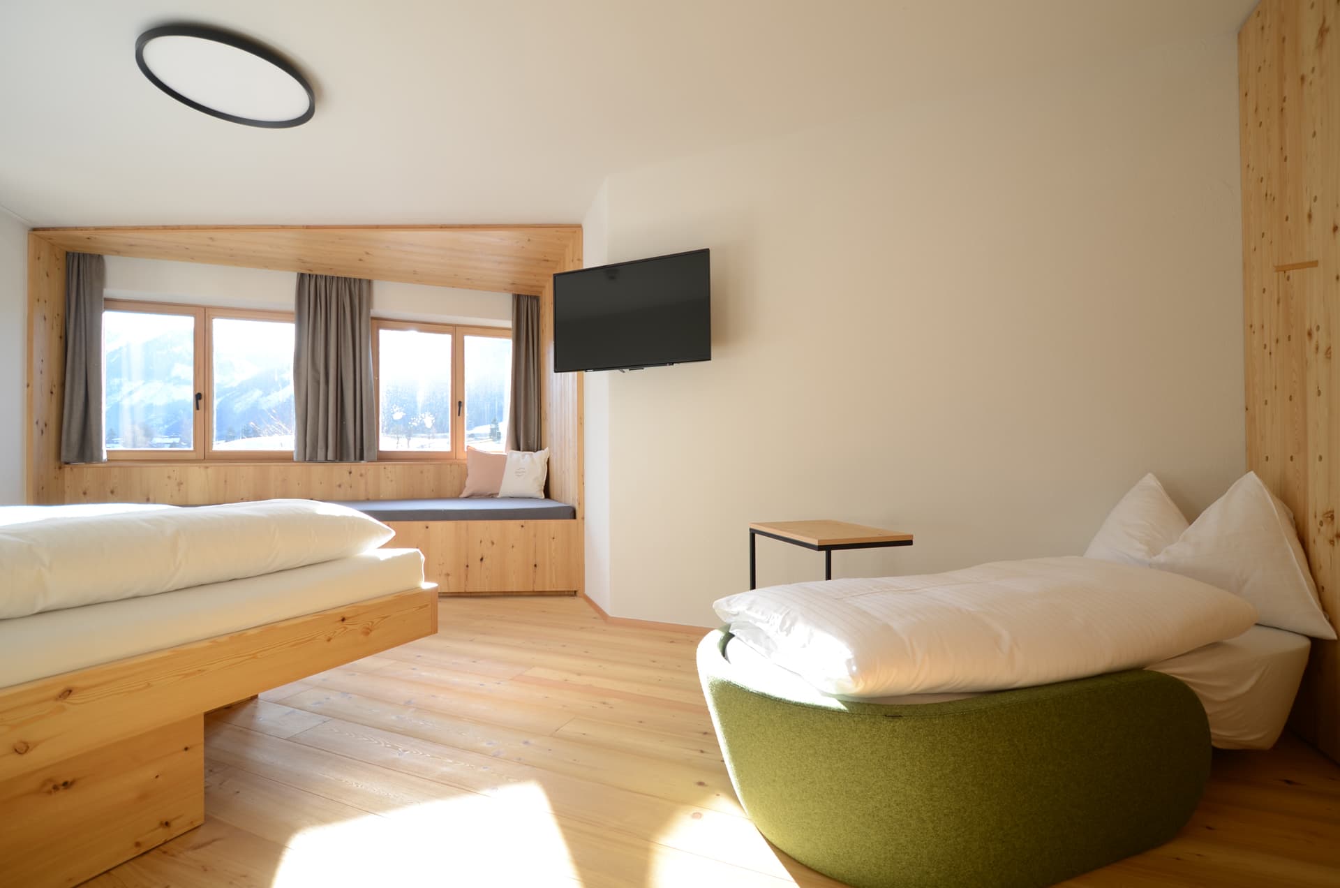 Schlafzimmer mit TV und Sessel und Fensterbett