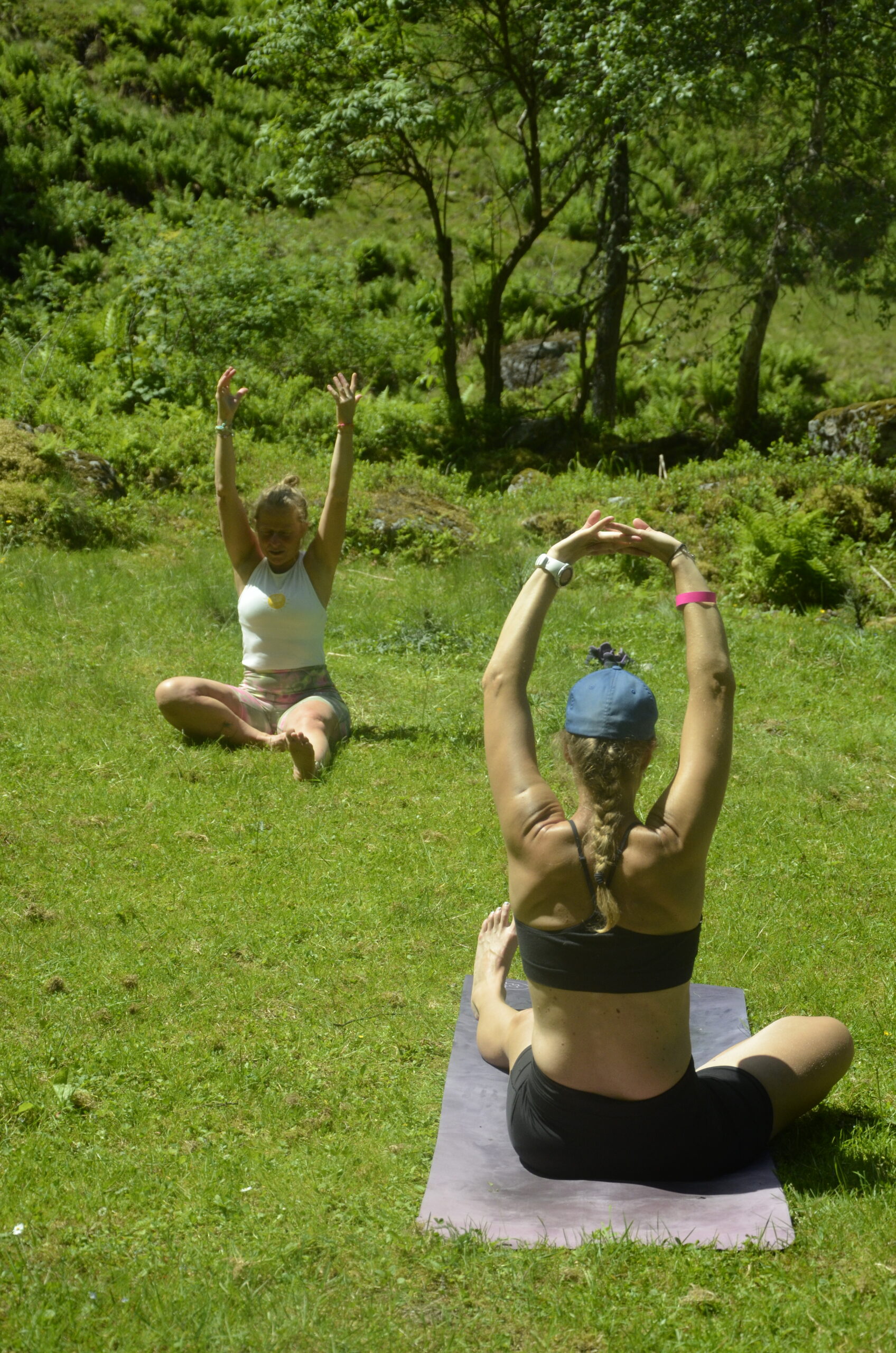 2 Frauen in Yogapose auf einer Almwiese
