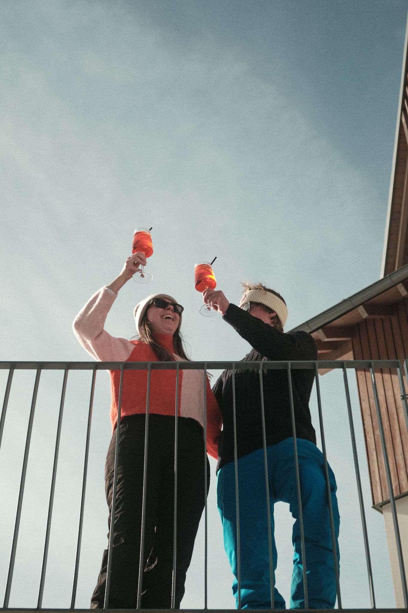 Zwei Personen stoßen an Balkon