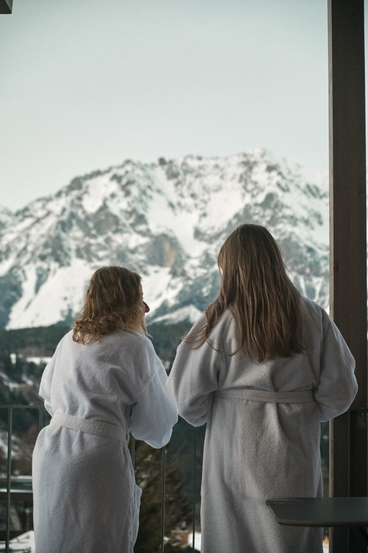Gäste im Bademantel am Balkon mit blick auf Dachstein