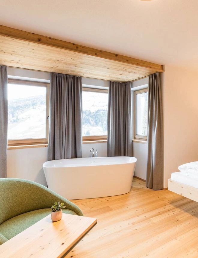 Schlafzimmer mit Badewanne und Fenster