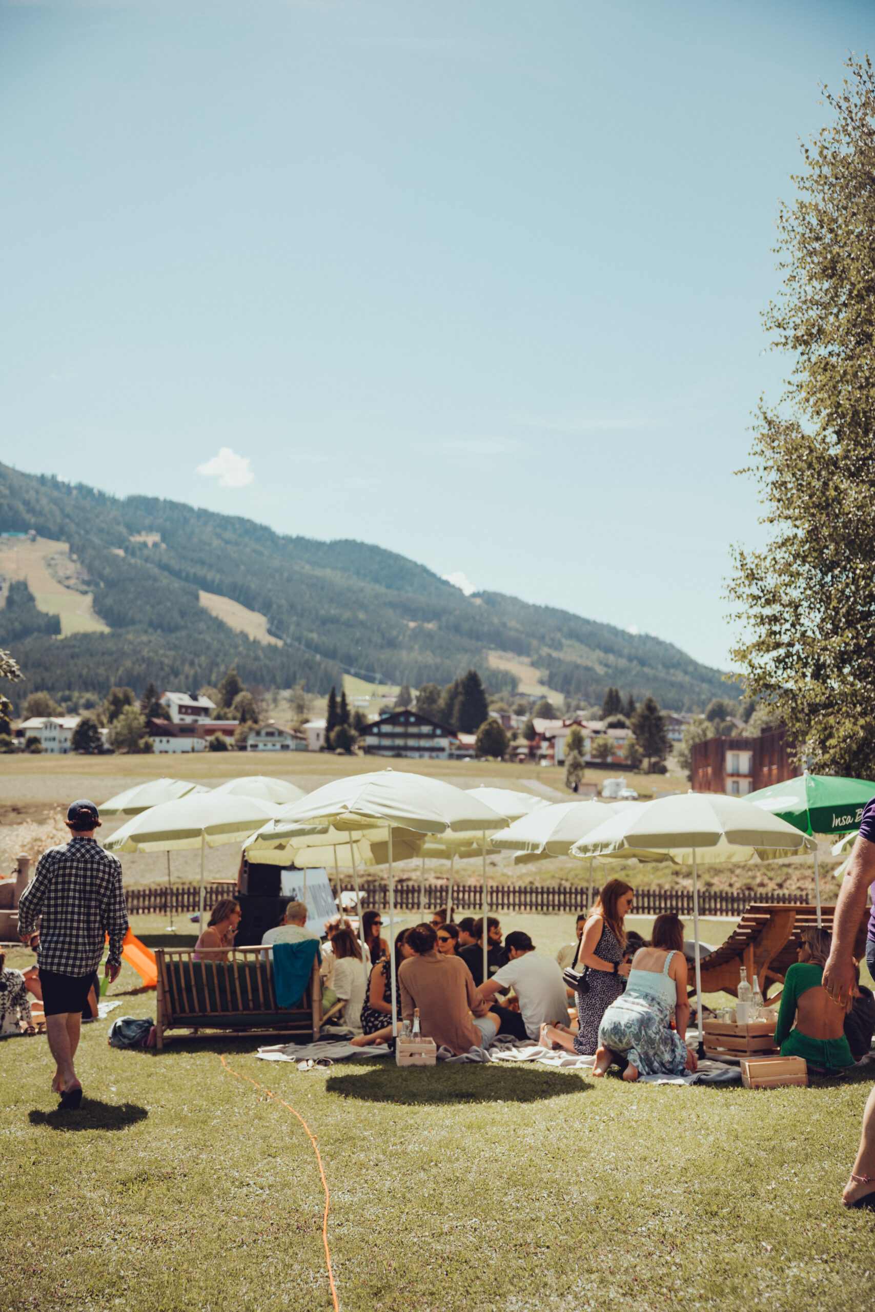 Menschen unter Sonnenschirmen auf der Wiese beim Picknicken