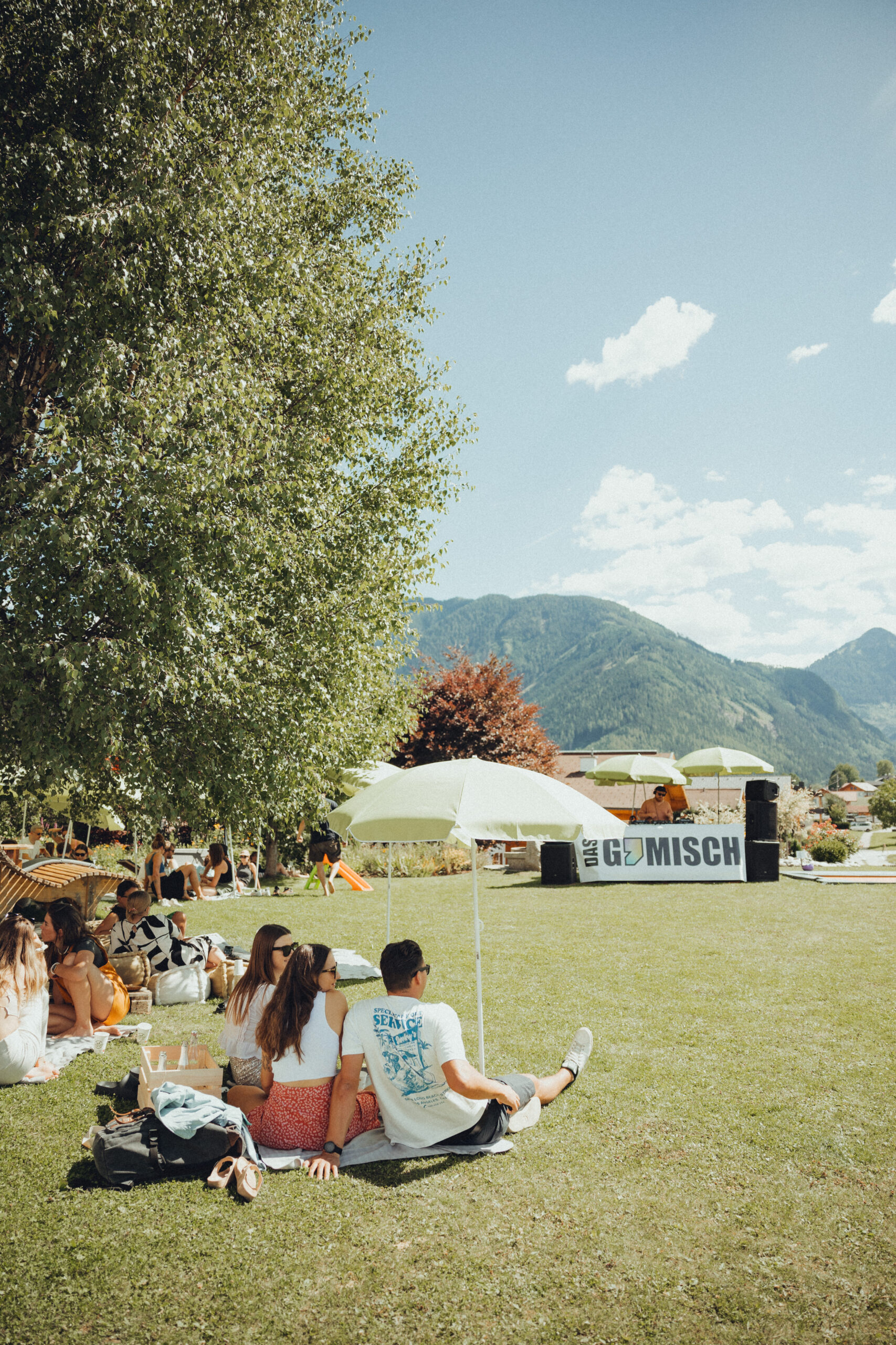 Menschen die auf einer Wiese sitzen und picknicken